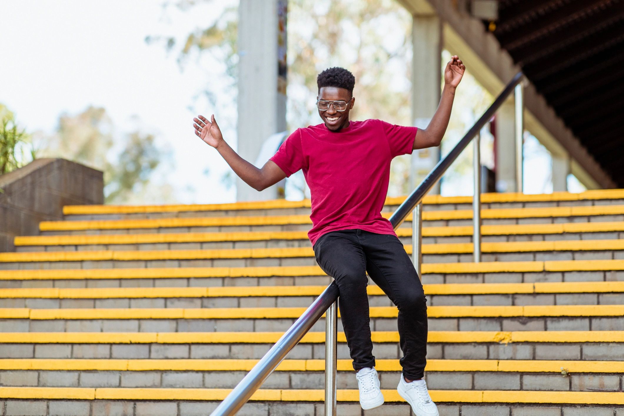Young man in casual streetwear sliding on a railing