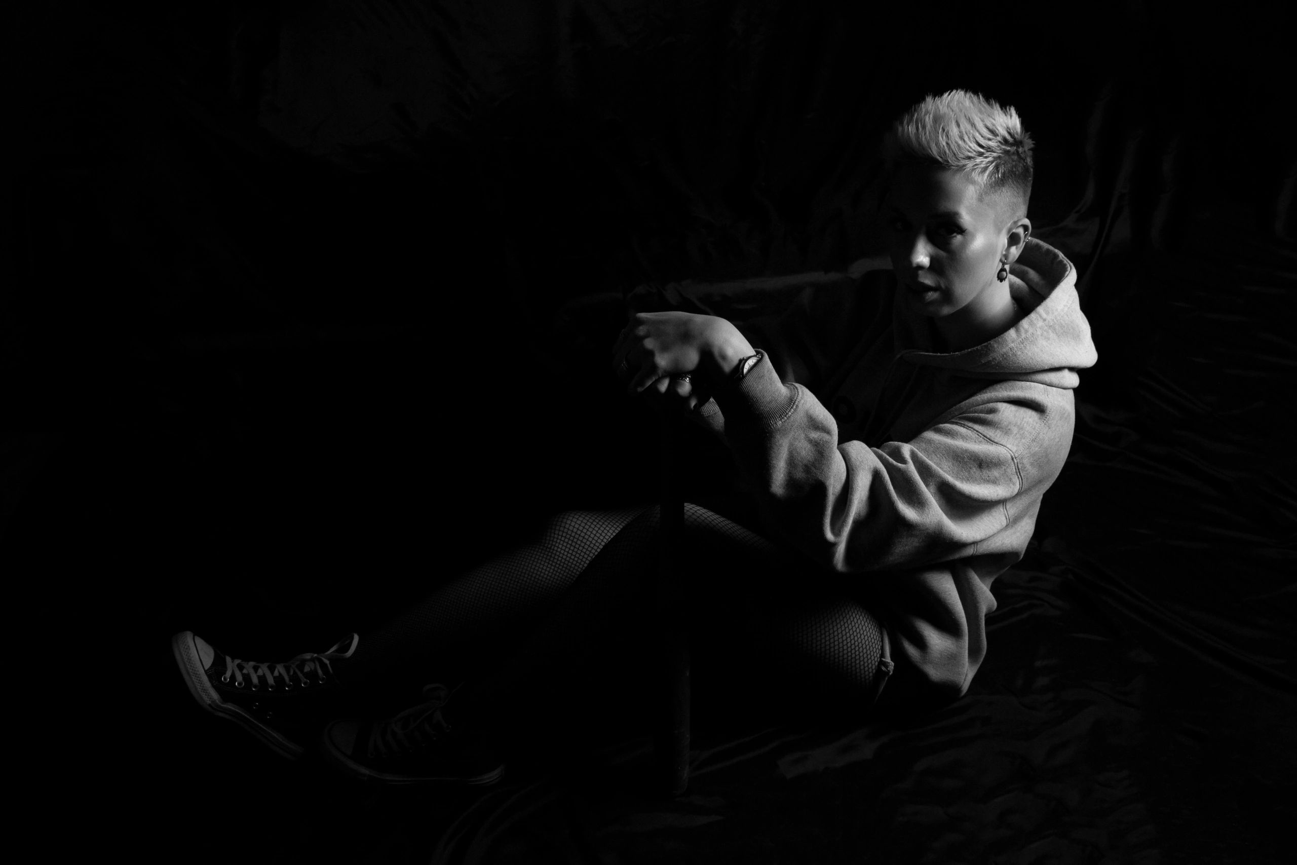 Young woman seated on the ground in black and white portrait