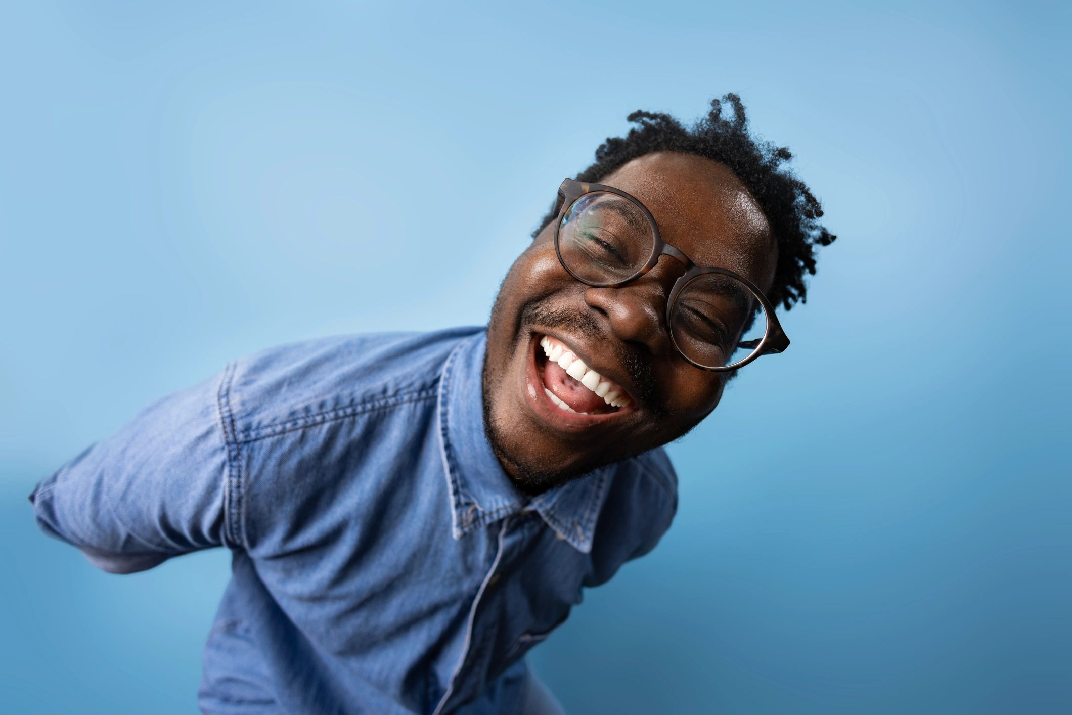 Cheerful man in streetwear against a studio background