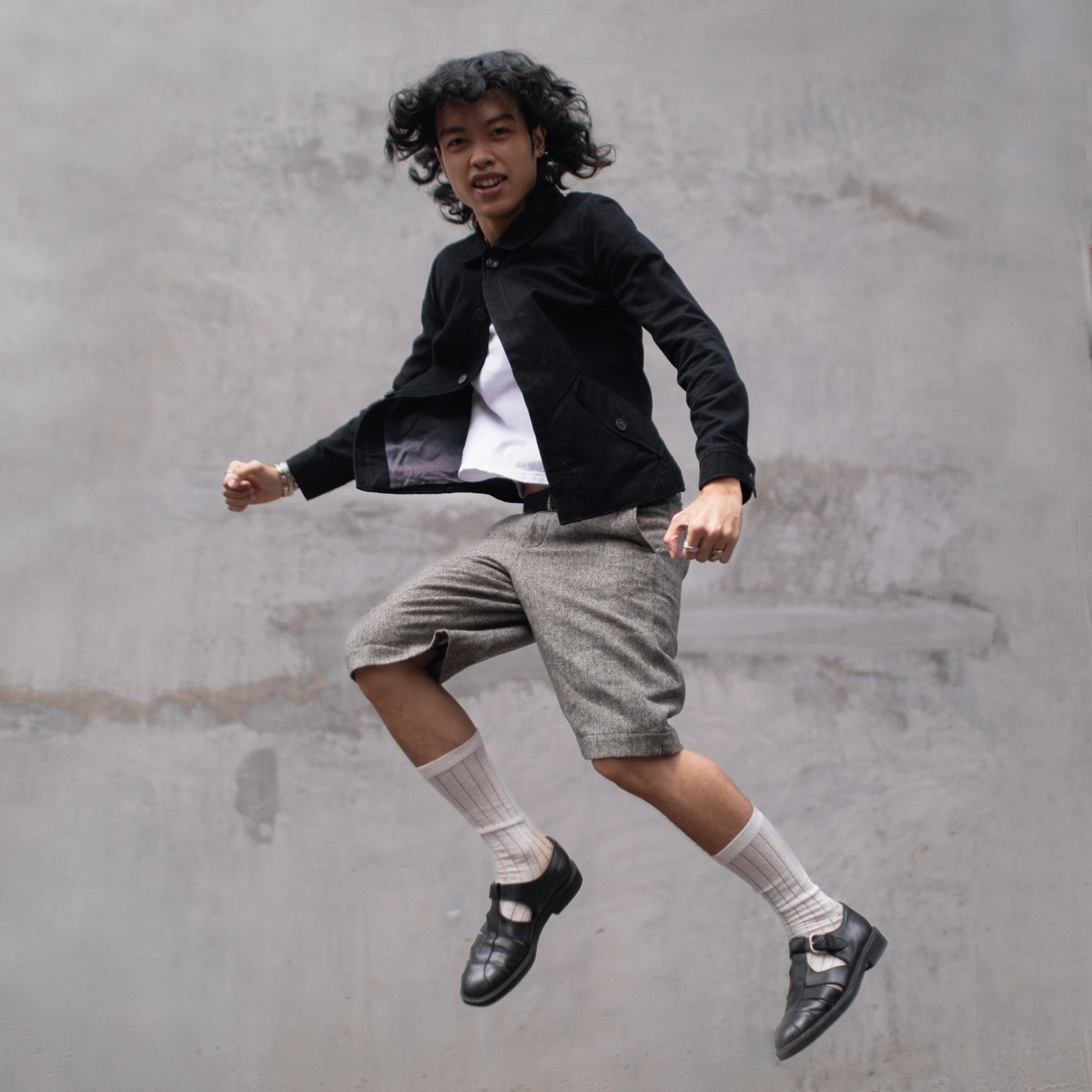 Fashionable young man jumping in streetwear style