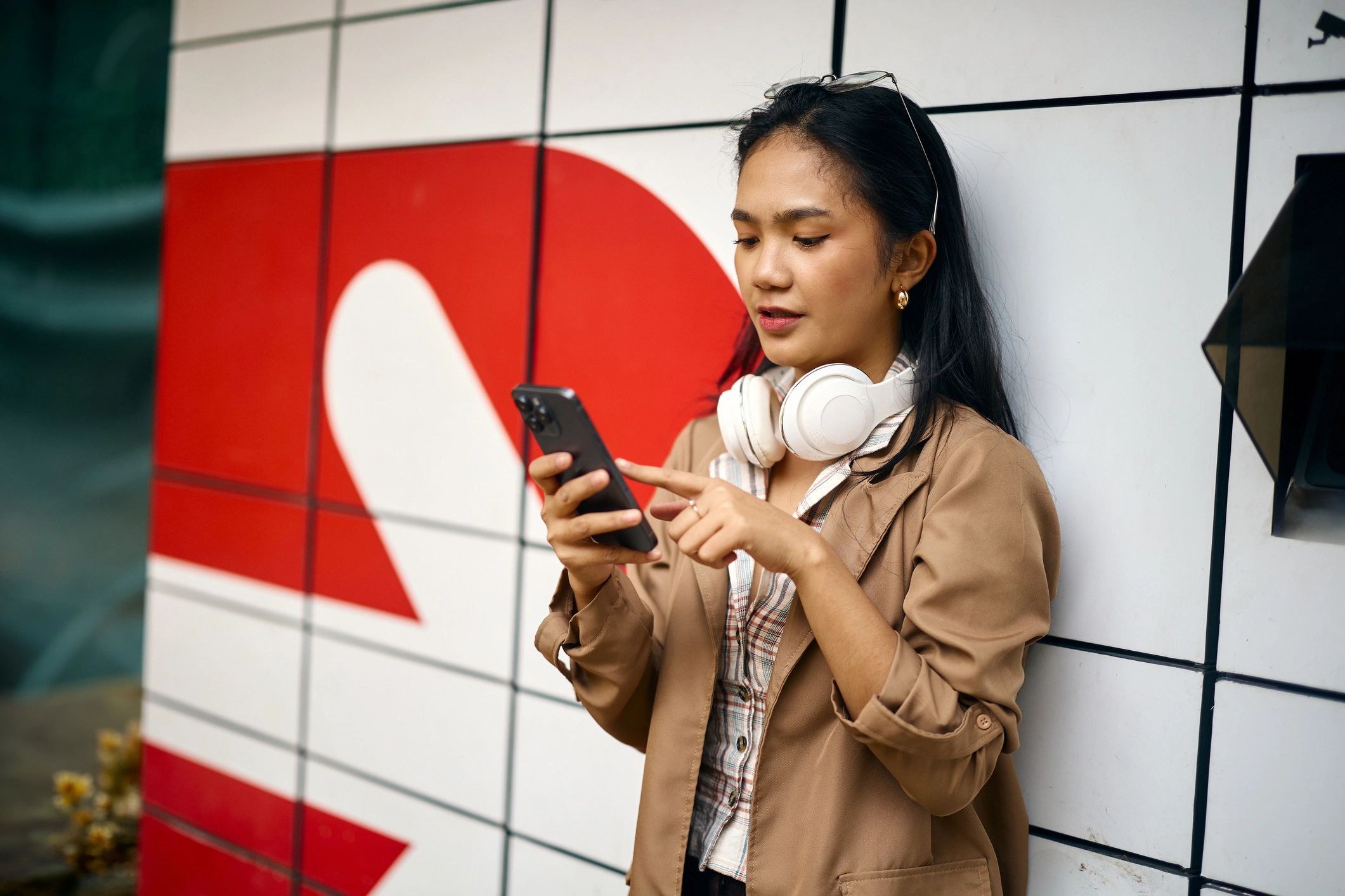 Young woman in casual urban fashion using smartphone
